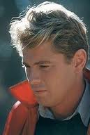 Tom Hoeck blond wave hair red jacket